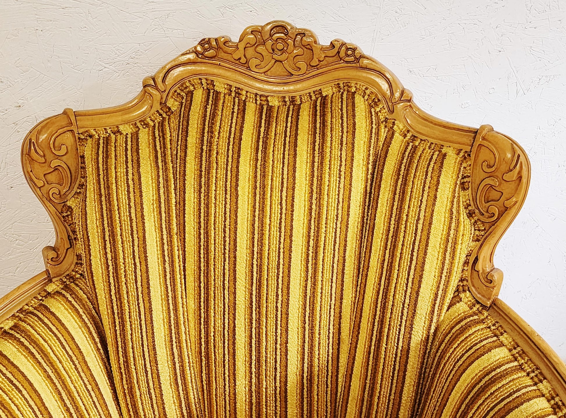 Gold ornate chair with detailed carvings on a white background